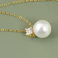 Elegante collar con colgante de perla redonda y circón en una fina cadena de oro 18K - Dorado