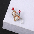 Macro detail of red floral brooch with white pearls on a textured jewelry box - Floral