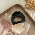 Macro view of black cutout acetate hair claw clip with golden inscription on tray - Semi-circle / Black
