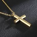 Makroaufnahme des polierten Goldkreuz-Anhängers mit Kordelkette auf schwarzem Lederhintergrund - Goldenes Kreuz Anhänger (KP93908-KFC)