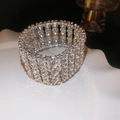 Macro shot of wide multi-row crystal elastic bracelet on a white ceramic display tray - Rectangular Shape / Silver
