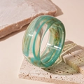 Détail d'un large bracelet en acrylique vintage avec texture marbrée vert et jaune - Bleu