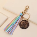 Detail of wooden MAMA charm with leather tassel on golden keyring for women - Rainbow