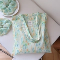 Detail der mintgrünen Aquarell-Stofftasche mit passendem Haargummi und Logo-Etikett - Umhängetaschen-Set