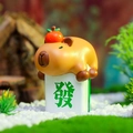 Macro detail of Capybara resin figurine with orange on white Mahjong tile in moss decor - Fortune Capybara (-059D)