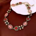 Detail einer Vintage-Goldkette mit rosa Kamee, rotem Herz und grünem Kleeblatt - 34# Halskette-Gold-Grün