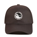 Close-up of white Tai Chi Yin Yang embroidery and Swimming text on brown baseball cap - Adjustable / Dark Gray