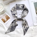 Detail of a black and white silk twilly scarf with lion and Z pattern on a magazine - Sketch Spring Letter Z