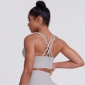 Dettaglio del reggiseno sportivo grigio chiaro con spalline incrociate e fascia elastica - Taglia S / Top / Verde basilico