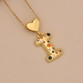 Close-up of golden letter I pendant with colorful zircon stones and heart detail - Letter I / Gold