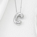 Macro shot of 3D puffy silver letter C balloon pendant on a fine O-chain necklace - Letter C Pendant