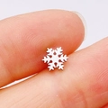 Polished silver snowflake stud earring made of stainless steel held between fingers - Silver Snowflake