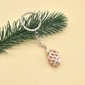 Detail of bohemian seashell keychain with brown patterns and golden metallic ring - Style 2 (Checkered Conch)