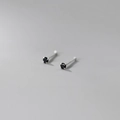 Macro shot of minimalist silver studs with four-prong set round black gemstones - 999 Fine Silver Pair - 2mm Black Zirconia