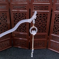 Detail of floral hair stick with tassels and pearlescent beads on a wooden background - White