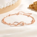Bracciale simbolo infinito oro rosa con zirconi lucenti su sfondo di seta elegante - Stile Oro Rosa