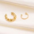Goldenes Ohrmanschetten-Set mit Lava-Struktur auf beigefarbenem Seidenhintergrund - Unregelmäßige Textur Und Glatte Stilkombination / Zweiteiliges Set / Gold