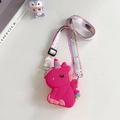 Detail of a bright rose pink unicorn silicone crossbody bag with rainbow strap on a desk - Rose Red