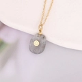 Close-up of gold chain necklace featuring a grey stone pendant with sun motif - Grey Oval Spotted Sun (14#)