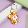 Cute 3D tiger cartoon keychain made of soft PVC on a minimalist purple background - Tiger