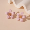 Primer plano de pendientes de flores rosas con centro dorado sobre fondo minimalista - Rosa