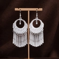 Dettaglio degli orecchini etnici in argento con nappine e motivi tribali incisi - E1624-2 (Nappa a Totem Traforato) / Argento