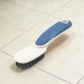 Detail of multi-functional shoe brush with blue-white handle and sturdy grey bristles - Blue