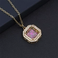 Detail view of gold octagonal necklace with rainbow crystal on black textured background - Pink and Green