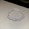 French irregular pearl bracelet with sparkling zircons on a textured beige surface - Silver Pink Rhinestone Bracelet