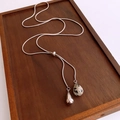 Détail d'une chaîne serpent argentée avec pendentif cœur en œil de tigre sur bois - Argent-Pierre Tachetée