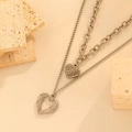 Detalle de collares de doble capa con corazones plateados sobre piedras decorativas - Estilo de corazón con alas de doble capa (I801) / Color Acero