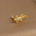 Macro shot of gold-plated gecko ear stud with sparkling zircon stones and screw back - Gecko Shape / Gold