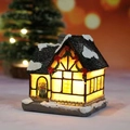 Miniatur-Weihnachtshaus aus Harz mit warmen LED-Lichtern und verschneitem Dach - Stil D