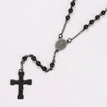 Macro shot of stainless steel rosary necklace with beads, Saint Benedict medal and crucifix - Black