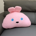Detalle de cojín de peluche de conejo rosa con textura suave sobre un sofá - 45x30cm / Conejo Rosa