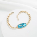 Detail of 18K gold plated bracelet featuring blue enamel Pisces charm and faux diamonds - Pisces