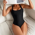 Chic black one-piece swimsuit with square neckline and wide straps shown on a beige sofa - S / Black