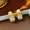 Macro shot of vintage pearl earrings with gold leaf detail and inlaid diamonds in a box - Gold