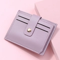 Close-up of lilac lychee grain leather card holder with gold circular metal buckle - Purple