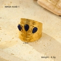 Detalle macro del anillo vintage dorado con textura plisada y tres piedras preciosas azules - Azul