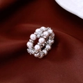 Macro detail of double-row pearl ring with sparkling diamond flowers on silk fabric - Silver