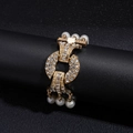 Dettaglio macro di un bracciale dorato multistrato di lusso con cristalli e perle bianche - Bracciale-Bianco