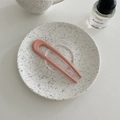 Roze matte U-vormige haarspeld gepresenteerd op een minimalistisch keramisch bord - Roze