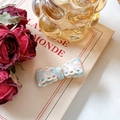 Barrette à cheveux élégante avec nœud à carreaux bleu et rose sur un livre ancien - Barrette / Bleu et Rose