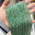 Light green faceted natural gemstone beads for jewelry making shown in a hand - Green Aventurine 3mm