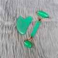 Green jade face roller and gua sha set with gold metal accents on plush background - Green Roller + Gua Sha Board