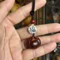 Detail of a handmade wooden persimmon and peanut keychain with traditional Chinese knots - Red Sandalwood Persimmon