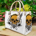 White PU leather tote bag with skull print and gold hardware on a wooden platform - White Lychee Pattern Skull Feather (手提包0040)