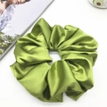 Nahaufnahme von hellgrünem Satin-Haargummi mit seidiger Textur und edlen Falten - 20cm / Grasgrün