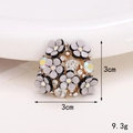 Macro shot of a floral gray brooch with gold plating and sparkling rhinestones 3cm size - Grey Gold Rhinestone Flower Cluster